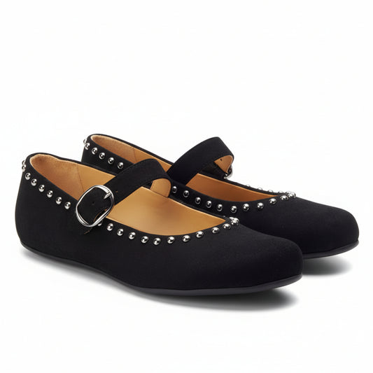 Die ZAQQ DIEQO Black Schuhe aus Veloursleder sind mit metallischen Nieten an den Rändern versehen. Sie sind mit einem sicheren Riemen und einer silbernen Schnalle ausgestattet und haben eine flache Sohle. Innen bieten sie eine hellbraune Innenausstattung für ein angenehmes Tragegefühl bei jedem Schritt.