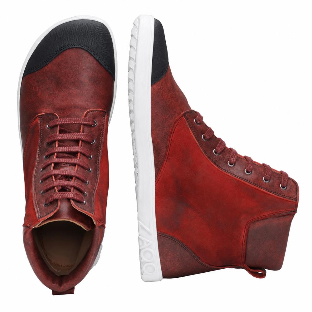 CHICAQO Red fra ZAQQ er et par high-top-sneakers laget av nappa- og semsket skinn med svart tåhette og hvit, fleksibel såle. En sko er utstilt oppreist for en sidevisning, mens den andre fremhever sine skolisser og det svarte frontdetaljen ovenfra. Merkenavnet ZAQQ er synlig på sålen.