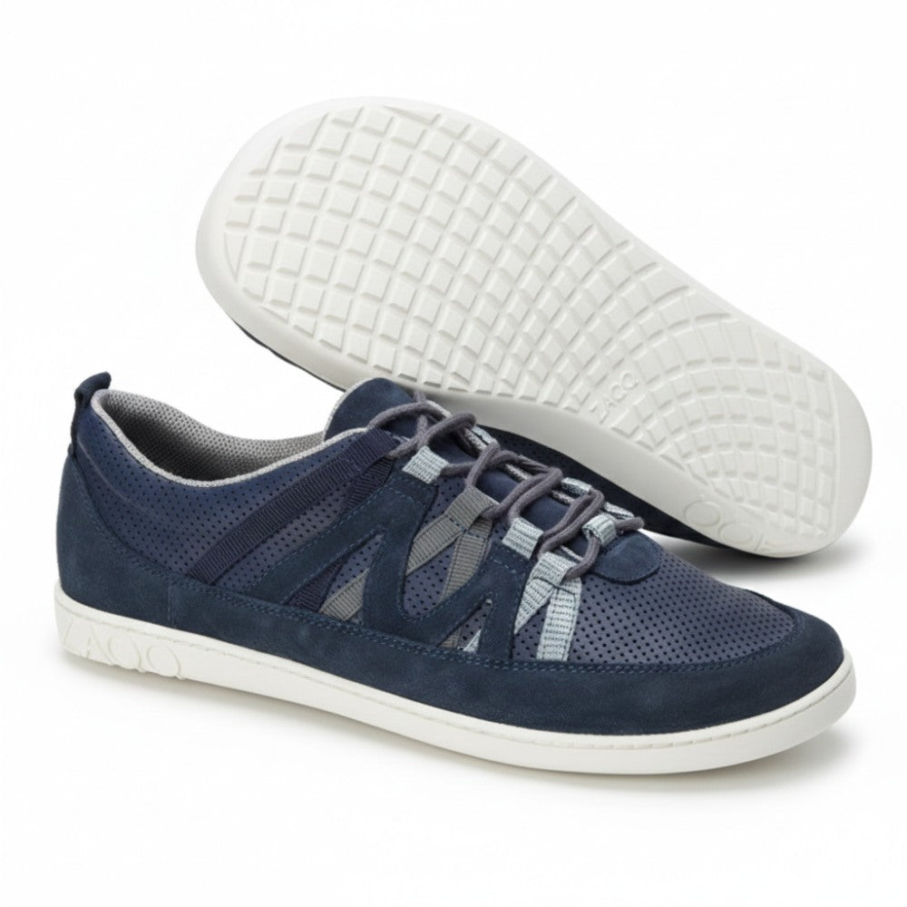 Die DRAQE Azul Sneaker von ZAQQ bieten außergewöhnlichen Tragekomfort und zeichnen sich durch ein stilvolles Design mit blauen und grauen Farbakzenten und weißen Sohlen aus. Die Schuhe zeichnen sich durch sich kreuzende Schnürsenkel und Mesh-Einsätze aus, ergänzt durch eine schlanke Sohle mit Gittermuster. Ein Schuh steht aufrecht, während der andere geneigt ist, um sein modernes Design hervorzuheben.