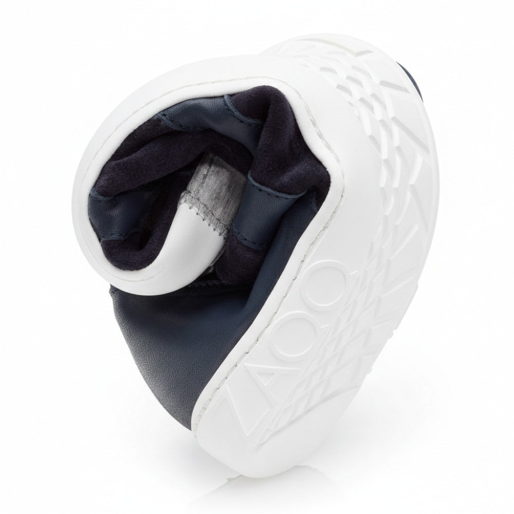 Ein Barfußschuh namens QAANAAQ Blue von ZAQQ verfügt über eine flexible Sohle, die spiralförmig verläuft und so ihr kariertes Muster zur Geltung bringt, wobei die Buchstaben ZAQQ deutlich auf der Seite zu sehen sind. Die dunkel gefütterte Innenseite besteht aus atmungsaktivem Material und unterstreicht sowohl die Flexibilität als auch das durchdachte Design.