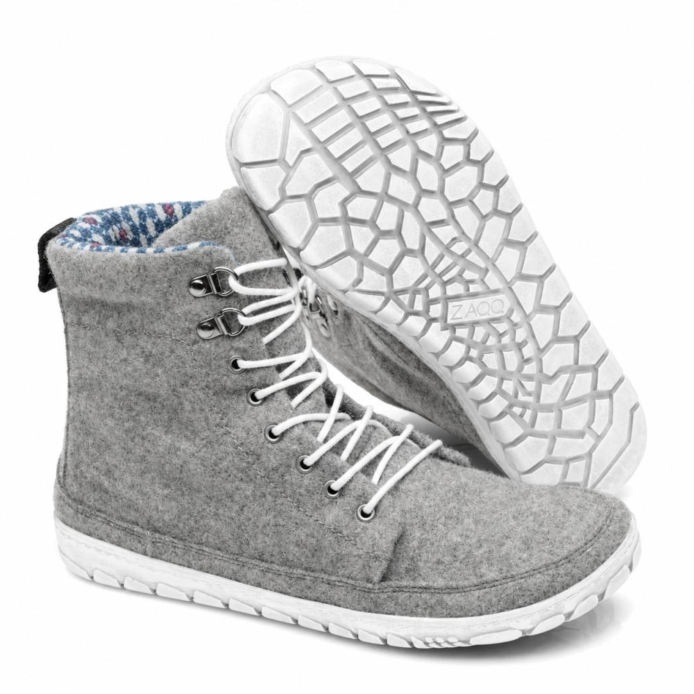 Utstilt er et par QICE Grey høye sneakers fra ZAQQ med hvite lisser. En sko står oppreist mens den andre er vinklet for å fremheve den strukturerte, mønstrede yttersålen.